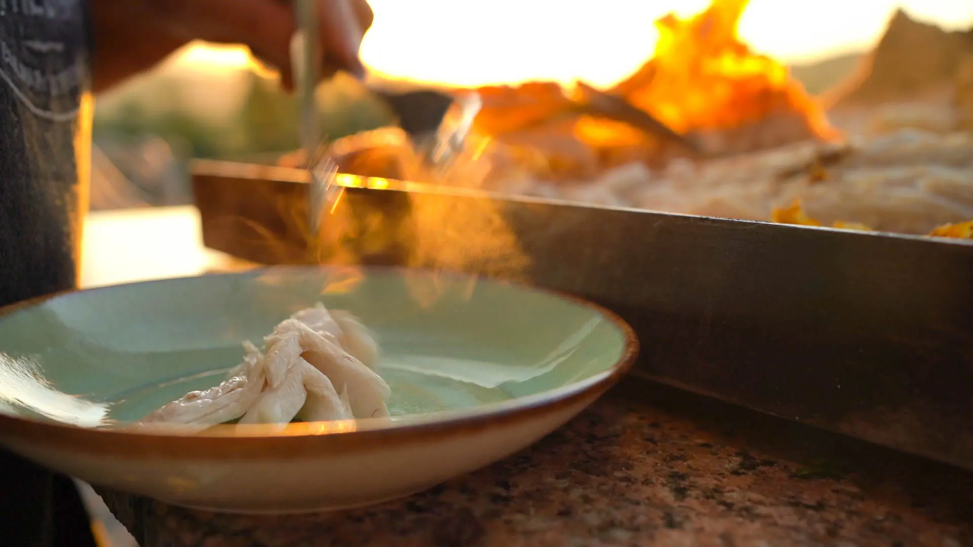 The chef plating by the open fire