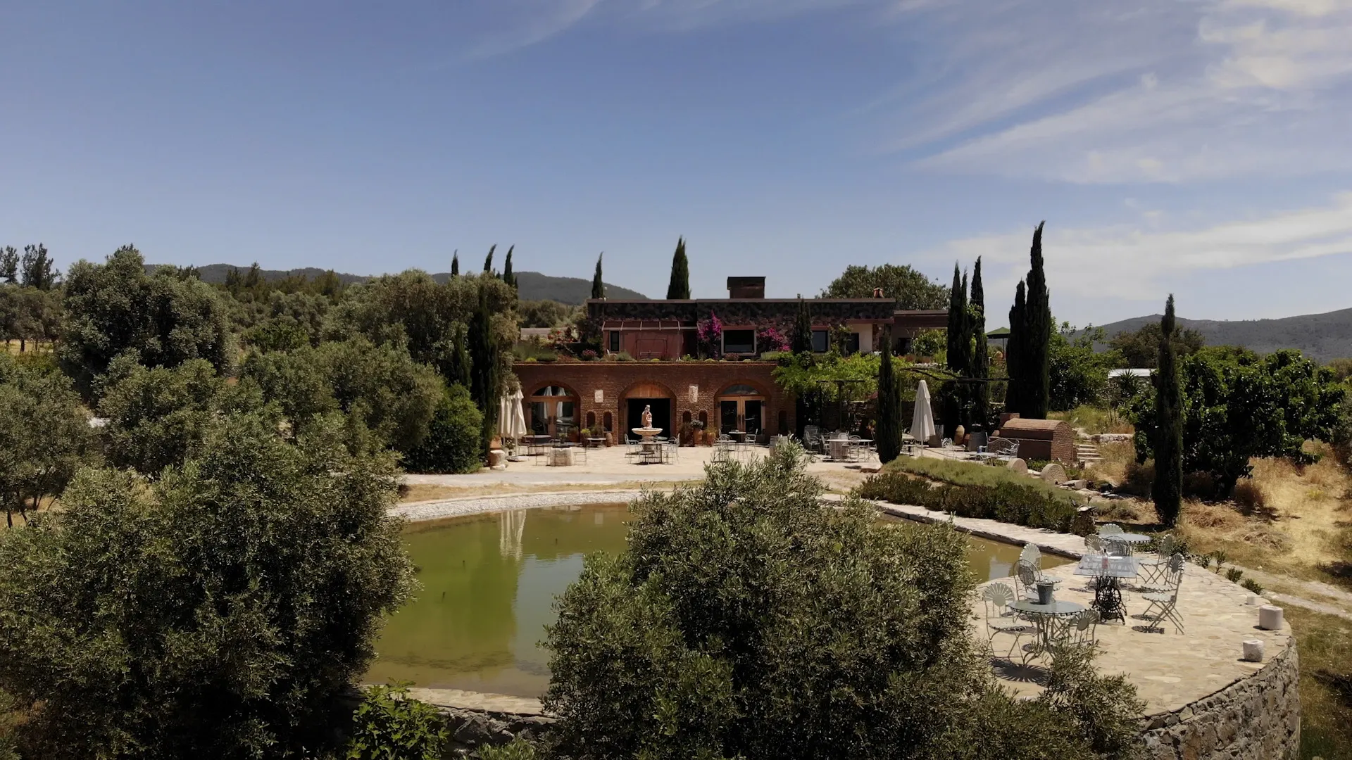 The Karnas main house and pond among olive trees